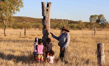 Ronnie Wavehill passing on knowledge of the early colonial life on Gurindji Country to his grandchildren. Image: Brenda L Croft An indigenous man speaking to his grandchildren